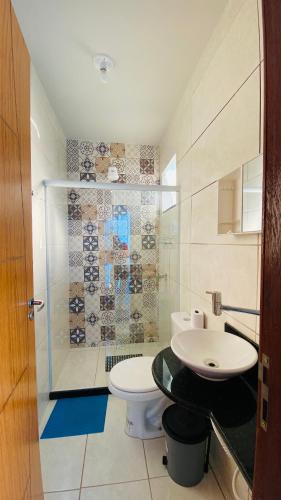 a bathroom with a toilet and a sink at Hanuá Beach House in Guarapari