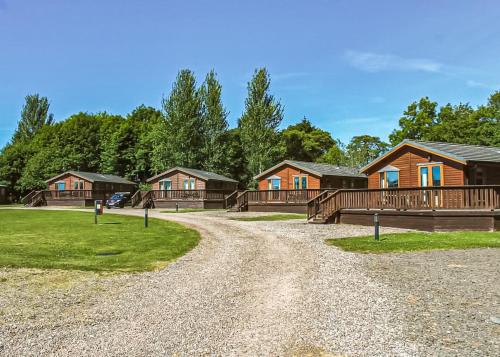 a gravel road in front of a group of cabins at Nethercraig Holiday Park in Alyth