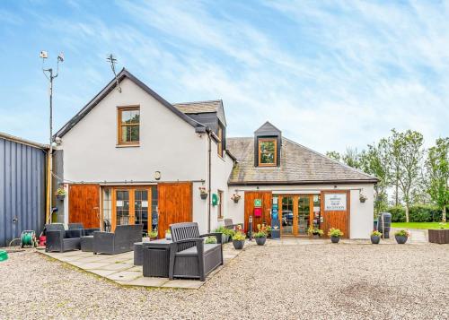 a white house with a patio with chairs at Nethercraig Holiday Park in Alyth