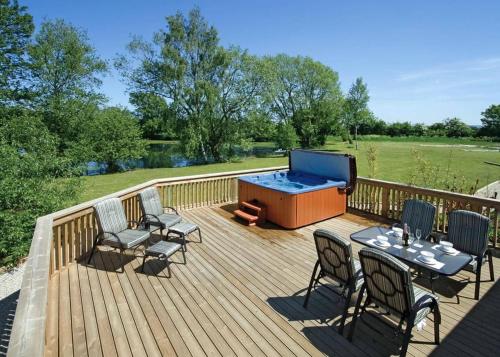 a wooden deck with chairs and a pool table and a ping at Pickering Lodges in Pickering
