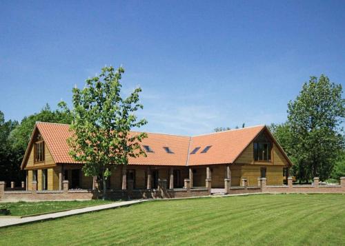 a large wooden house with a tree in the yard at Pickering Lodges in Pickering