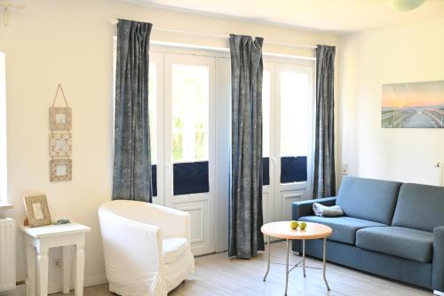 a living room with a blue couch and a table at Landsitzhotel und Seminarium Peterhof in Hodorf