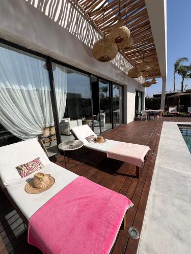 a bedroom with a bed and a deck with a pool at Villa Alanaé piscine chauffée in Douar Bellouk