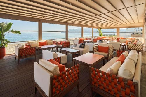 a restaurant with couches and tables and the ocean at Sofitel Tamuda Bay Beach And Spa in M'diq