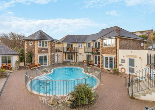ein großes Haus mit einem davorliegenden Swimmingpool in der Unterkunft Porth Veor in Newquay