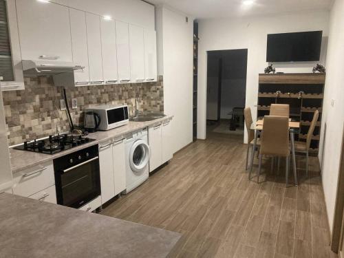 a kitchen with white cabinets and a table with a microwave at Relax and Explore the City in Chişinău