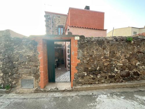 a building with a stone wall and a doorway at Maison de l artiste Zangs in Narbolia
