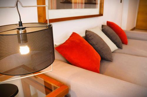 a couch with pillows and a lamp on it at HOM I Departamento en Valle Nevado Amplio Dúplex 6PAX SKIOUT in Farellones