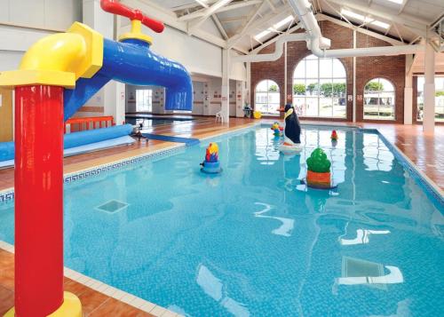 a swimming pool with a water slide in it at Robin Hood Rhyl in Rhyl