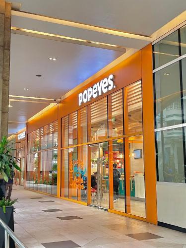 a store front of a poeyes store with its doors open at NAIA Terminal 3 Condo Newport with WIFI Netflix Pool in Manila