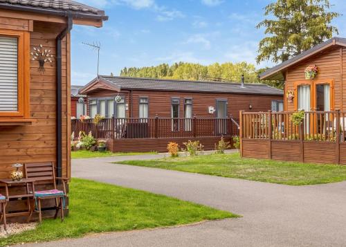 a row of houses with a fence and a yard at Roydon Marina Village in Roydon
