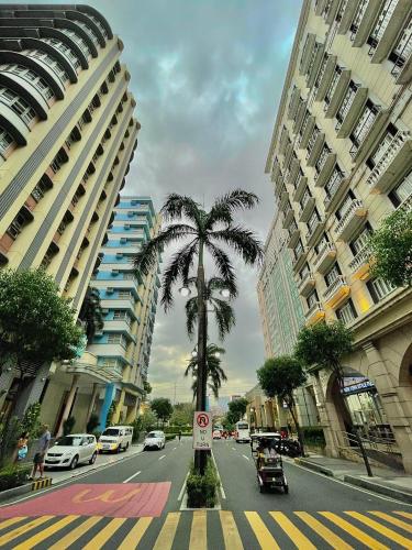 a city street with a palm tree and buildings at NAIA Terminal 3 Condo Newport with WIFI Netflix Pool in Manila