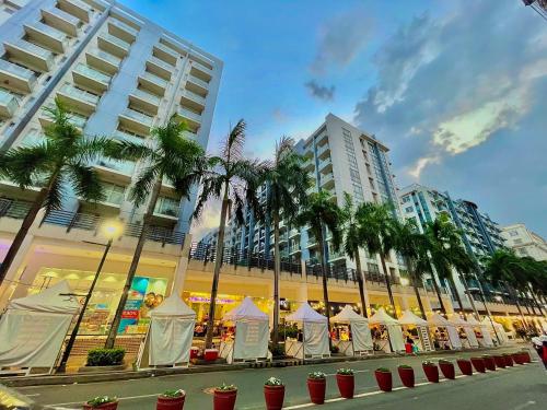 a street with palm trees in front of a building at NAIA Terminal 3 Condo Newport with WIFI Netflix Pool in Manila