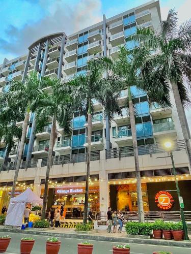 a large building with palm trees in front of it at NAIA Terminal 3 Condo Newport with WIFI Netflix Pool in Manila