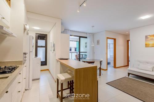 a kitchen and living room with a couch and a table at Apto Moderno c/ piscina prox. da Praia AVR0203 in Piçarras