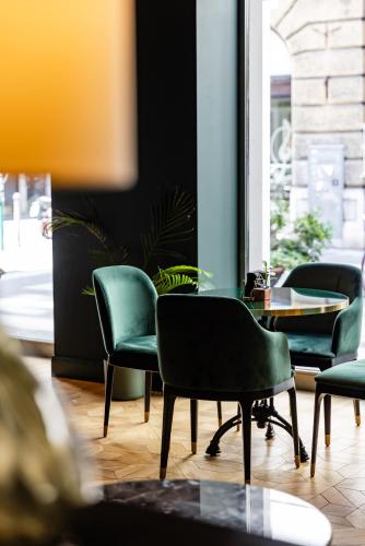 four chairs and a table in a room at Hotel Continentale in Trieste