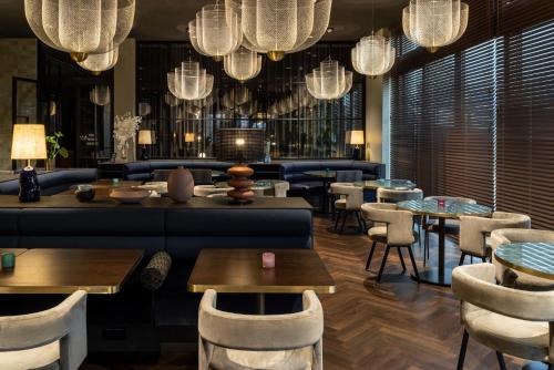 a restaurant with a blue couch and tables and chairs at Hotel ROMY by AMANO in Berlin