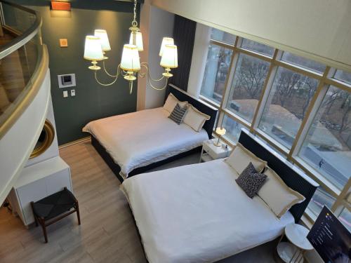 a small room with two beds and a window at Gleam House in Seoul