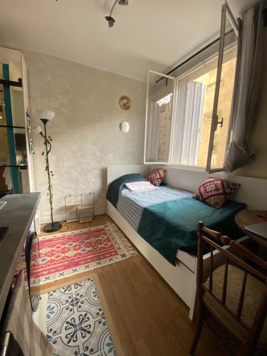 une petite chambre avec un lit et une fenêtre dans l'établissement Charming Arty Studio, à Paris
