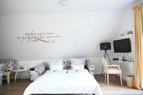 a bedroom with a bed and a desk with a tv at Landsitzhotel und Seminarium Peterhof in Hodorf
