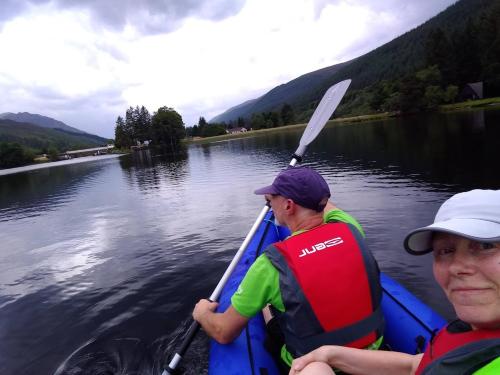 two people in a paddle boat on a river at True North Lodge - A cosy wee highland Getaway in Spean Bridge