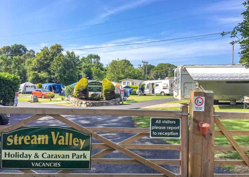 a gate with a sign that reads strength valley holiday and caravan park at Stream Valley Holiday Park in Penzance