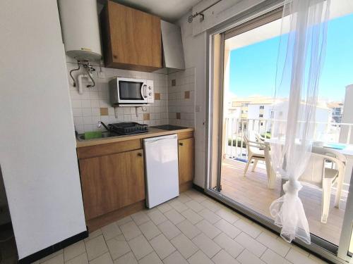 Il dispose d'un balcon et d'une cuisine équipée d'un réfrigérateur. dans l'établissement 031 Palmeraie Studio avec parking plage du môle, au Cap d'Agde