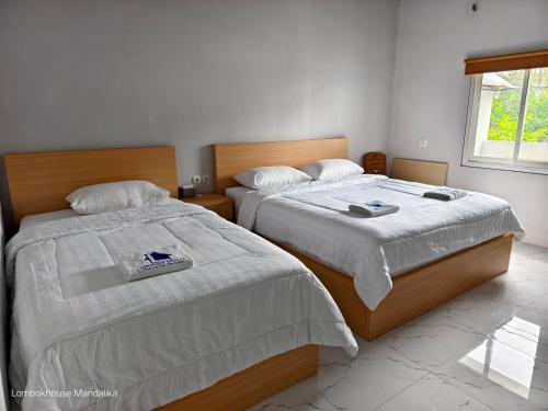 two beds sitting next to each other in a bedroom at Lombokhouse Mandalika in Kuta Lombok