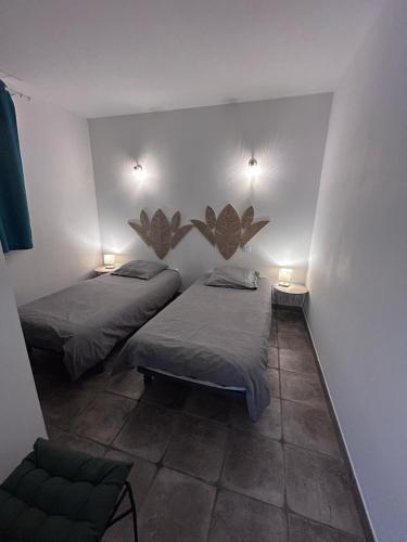 - 2 lits dans une chambre avec 2 lampes sur le mur dans l'établissement Pietralba Un havre de paix entre mer et montagnes, à Pietralba