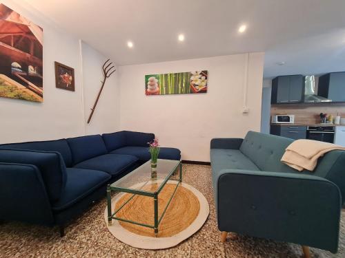 un salon avec deux canapés bleus et une table dans l'établissement Maison familiale rénovée avec wifi, proche de sites historiques - FR-1-584-371, à Mont-lʼÉtroit
