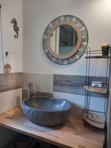 La salle de bains est pourvue d'un grand lavabo en pierre et d'un miroir. dans l'établissement Ty'ca house, à Velleron