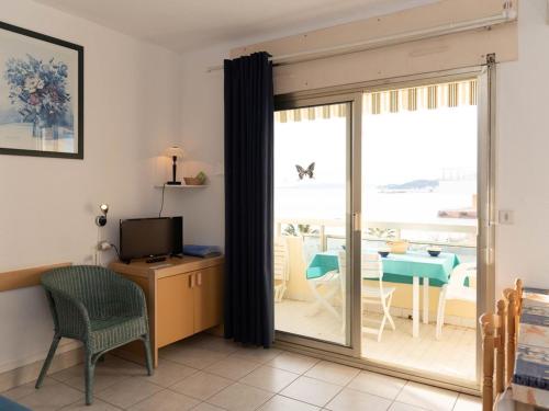 un salon avec une porte coulissante en verre et une télévision dans l'établissement Studio cabine 4 pers, vue mer, clim, parking, Le Lavandou - FR-1-803-91, au Lavandou