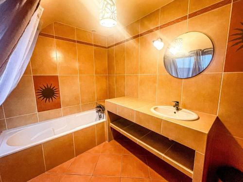 une salle de bain avec un lavabo, une baignoire et un miroir dans l'établissement Maison contemporaine à Erdeven - 5 chambres, animaux acceptés - FR-1-479-223, à Erdeven