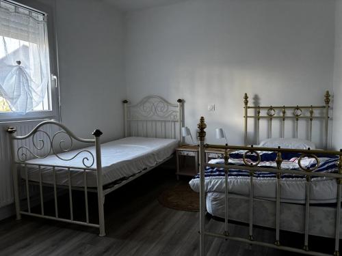 deux lits jumeaux dans une chambre avec fenêtre dans l'établissement Maison PMR plain-pied avec jardin, 3 chambres, 6 pers., animaux sur demande, proche Ria d'Etel - FR-1-397-85, à Belz
