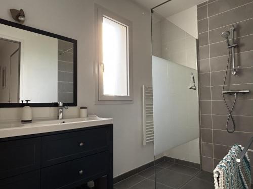 une salle de bain avec un lavabo et une douche avec un miroir dans l'établissement Maison PMR plain-pied avec jardin, 3 chambres, 6 pers., animaux sur demande, proche Ria d'Etel - FR-1-397-85, à Belz