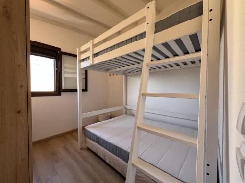 une chambre avec deux lits superposés et une fenêtre dans l'établissement Appartement T2 Climatise avec Parking proche Plage - FR-1-81-631, à Port-Leucate