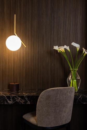 a room with a chair and a vase with flowers at Hotel Continentale in Trieste