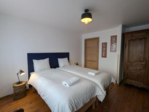 a bedroom with a large white bed with a blue headboard at Gîte historique et moderne, capacité flexible - FR-1-585-170 in Mouzay