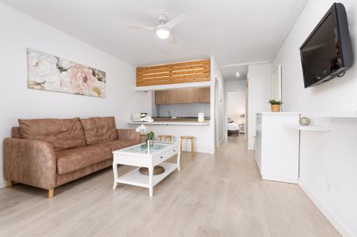 ein Wohnzimmer mit Couch und Tisch in der Unterkunft Home2Book Tranquil Escape Corralejo Community Pool in Corralejo
