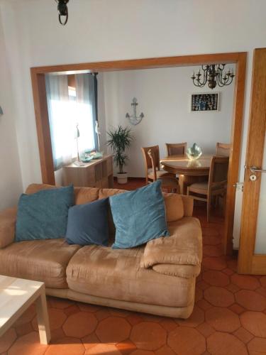a living room with a brown couch with blue pillows at Casa de Mi mar in Viana do Castelo