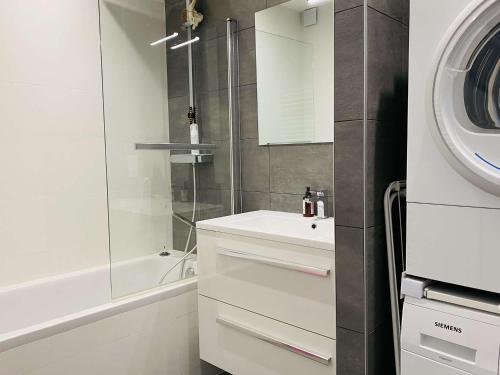 une salle de bain blanche avec un lavabo et une douche dans l'établissement Charmant Duplex 6-7 Pers avec Wifi et Parking à La Baule - FR-1-392-244, à La Baule-les-Pins
