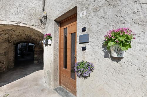 a building with flower boxes on the side of a door at Dina’s Flower House in Lierna