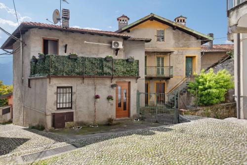 an old house with ivy growing on the side of it at Dina’s Flower House in Lierna