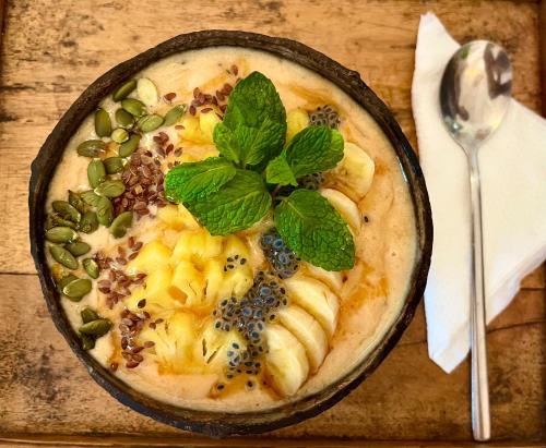 a bowl of food on a wooden table at Seconds Hostel - Colombo in Colombo