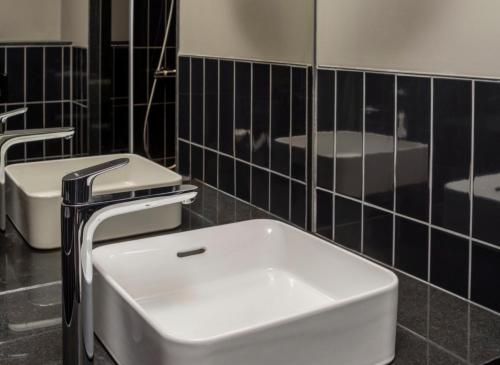 a bathroom with two sinks and a white sink at Hotel ROMY by AMANO in Berlin