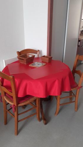 une table avec un tissu de table rouge et deux chaises dans l'établissement Appartement 30 m2 - 2 pers - Plein sud - 1er étage, à Tarbes