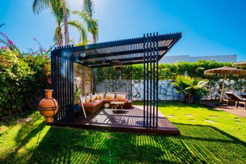 a pergola with a couch in a yard at Villa Alanaé piscine chauffée in Douar Bellouk
