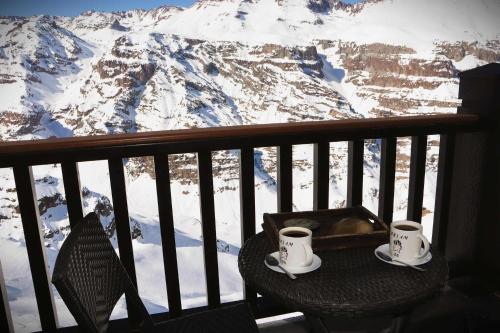 2 tazas de café en una mesa en un balcón con una montaña en HOM I Vc1702, en Farellones