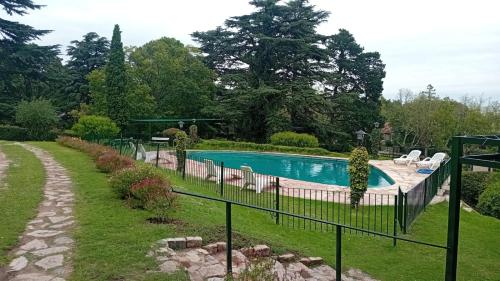 a fence around a swimming pool in a yard at Posada los Cedros in La Cumbre