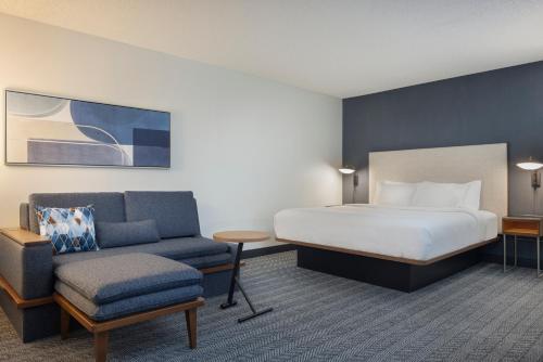a hotel room with a bed and a chair at Courtyard by Marriott Springfield Airport in Springfield